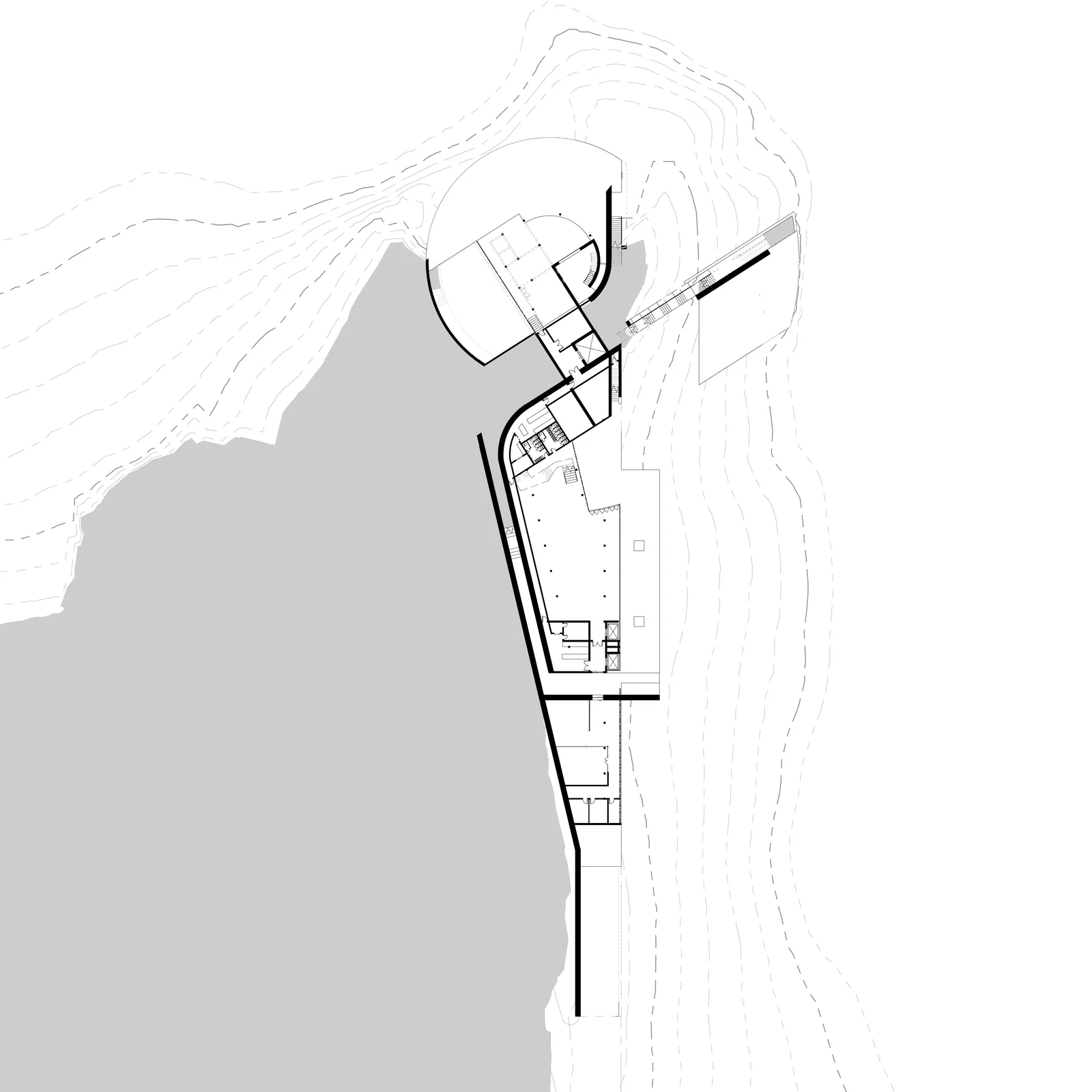 First floor plan: the curved public wing over the reflecting pool, the long wing stepping down the site.
