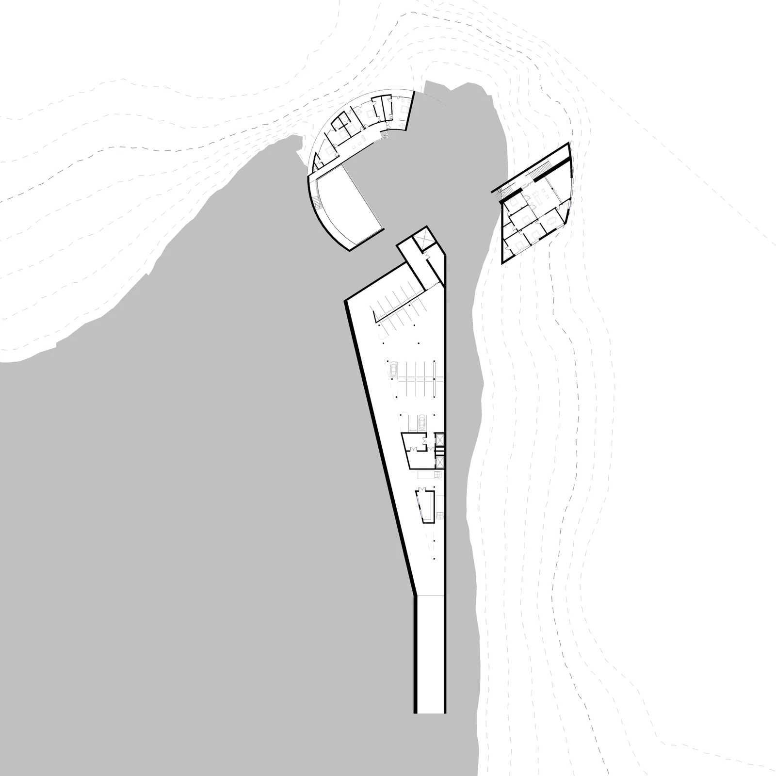 Lower ground floor plan: the car park and service spine cut into the slope, the curved wing above it, the lake to the west.